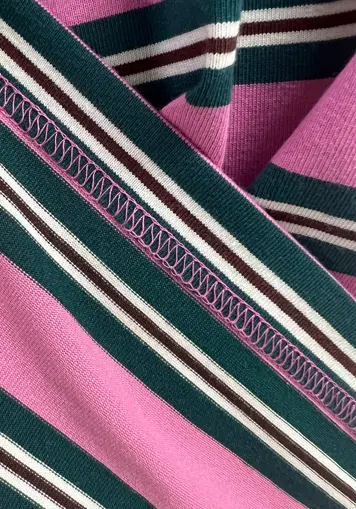 Close up texture of pink green striped fabric for long sleeve polo shirt