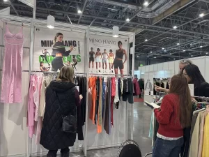 Visitors reviewing custom apparel samples at the Minghang Garments booth.