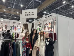 Visitors reviewing custom apparel samples at the Minghang Garments booth.