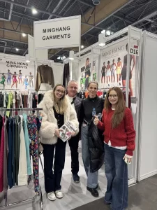 Visitors reviewing custom apparel samples at the Minghang Garments booth.